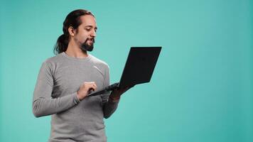 Man using laptop to do business related tasks for company, isolated over studio background. Office clerk doing budgeting, forecasting, and financial analysis on notebook, camera B video