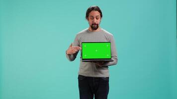 Portrait of worker holding isolated screen laptop, doing important work for company, studio background. Employee with chroma key device at work solving job tasks, camera A video