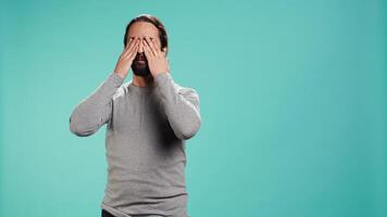 Man covering eyes, ears and mouth, imitating three wise monkeys. Arab person doing dont see, dont hear and dont speak hand gesturing concept, studio background, camera B video