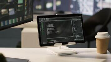 Programming language on digital device screen in empty IT department office used for app development. Close up of tablet left open on desk in tech startup company workspace with nobody in video
