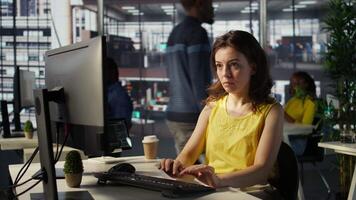 Portrait of smiling programmer creating machine learning models that can process and analyze data to automate decision making processes. Cheerful IT professional programming in office, camera B video
