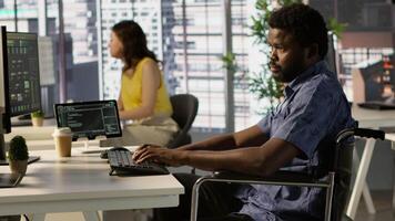 Software technician with disability in inclusive workplace working with machine learning tech. African american IT expert with paraplegia in wheelchair transforms data into predictive models video