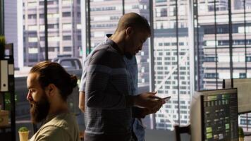 Managers evaluating work done by computer scientists in workspace doing software debugging. Management executives walking in office with tablet, checking code fixed by employees, camera A video