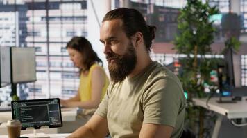Employee looking at PC monitor, drinking coffee, checking data needed for finding business insights and finishing project task. Man analyzing data on computer, enjoying beverage, camera A video