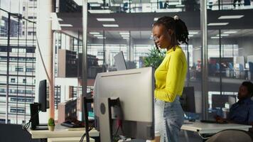 Computer scientist working, doing software debugging using notebook, troubleshooting errors. Woman standing in office, fixing coding issues using laptop, solving tasks, camera B video