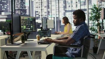 Software technician with disability in inclusive workplace working with machine learning tech. African american IT expert with paraplegia in wheelchair transforms data into predictive models video