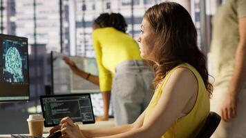 Admin tests on computer and tablet to optimize artificial intelligence machine learning models for performance and accuracy. IT worker in office analyzing and interpreting complex AI data, camera A video