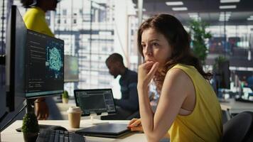Woman in office using laptop to steal company secrets after being hired by competitor, hiding from manager. Sneaky employee closing notebook lid to hide while ilegally downloading data, camera B video