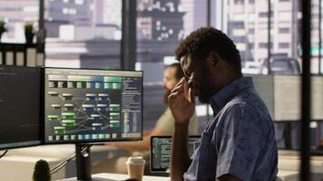 System administrator in office yawning during shift, feeling tired while looking at software interface on PC. Exhausted man being sleepy in workspace, programming on computer monitor, camera A video