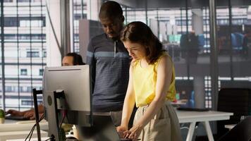 African american supervisor looking at laptop screen with employee, checking on finished project task. Company management executive and woman analyzing data on notebook, camera A video