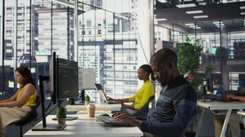 Happy coworker in wheelchair bumping fists with programmer testing machine learning technology. Person with disability saluting colleague in inclusive office, doing friendly gesture, camera B video