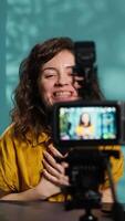 Vertical Streamer doing live broadcast talking to audience about recent news headlines, reading from mobile phone screen. Woman talking with viewers, presenting information read from smartphone, camera A video