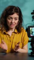 Vertical Enthusiastic internet show host hitting the record button on professional camera, using microphone to talk about today topic with subscribers. Media star filming creative vlog, camera A video