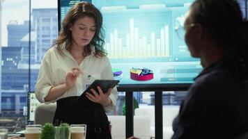 Diverse work team collaborating on project management tasks, utilizing smart technology and detailed analytics to optimize resource allocation and ensure enterprise objectives. Camera A. video