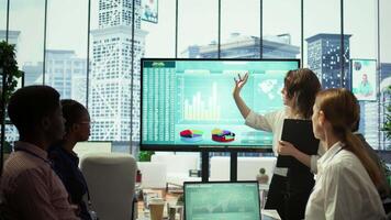 Corporate associates looking into project details and timetables in conference room, establishing budget and operations to accomplish objectives in a competitive business environment. Camera B. video