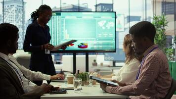 Diverse work team collaborating on project management tasks, utilizing smart technology and detailed analytics to optimize resource allocation and ensure enterprise objectives. Camera B. video