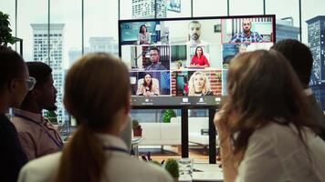 Company employees attending a meeting via videocall with investors, discussing about the future of the enterprise. Advisory board and workers examining infographics data for management. Camera B. video