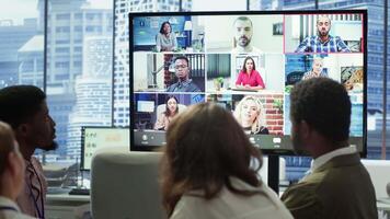 empresa empleados asistiendo un reunión vía videollamada con inversores, que se discute acerca de el futuro de el empresa. consultivo tablero y trabajadores examinando infografia datos para gestión. cámara una. video