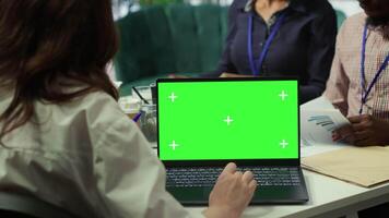 Diverse team of business associates looking at mockup chroma key screen during executive board meeting, utilizing smart technology. Enterprise staff develop effective business strategies. Camera A. video
