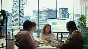 General director sharing insight about a new expansion strategy with her employees, presenting data reports to analyze business activity status. Coworkers in a briefing meeting. Camera B. video