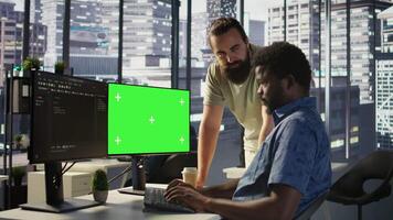 Admin doing software debugging on green screen PC, asking for help from coworker, checking errors in code. Worker fixing coding mistakes on mockup computer, being assisted by colleague, camera B video
