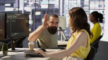 Cheerful manager in wheelchair doing high five with employee testing machine learning software. Team leader with disability saluting worker, doing friendly gesture, camera A video