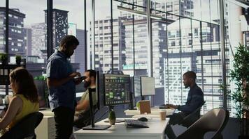 computador cientista retomar trabalhos depois de passeando dentro área de trabalho, fazendo Programas depuração usando pc. homem caminhando com tábua dentro escritório, fixação codificação problemas usando computador, Câmera b video