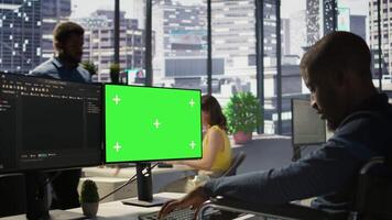 Man with disability in inclusive workplace working with machine learning tech on green screen computer. African american IT expert with paraplegia in wheelchair works with data on mockup PC, camera B video