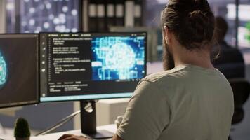 Software technician using computer for artificial intelligence computing simulating human brain. Close up of employee working with AI deep neural networks on desktop PC, camera A video
