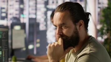 nachdenklich Mitarbeiter mit Computer zu analysieren Datensätze, konzentriert auf Vergleichen Datensätze und Überprüfung Buchhaltung Zahlen. schließen oben von Mann Konzentration auf lösen Aufgaben zum Mannschaft Projekt, Kamera ein video