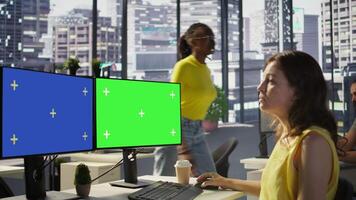 Employee using multi monitor isolated screen computer to analyze datasets, comparing accounting figures. Woman using chroma key PC to solve tasks for team project, camera B video