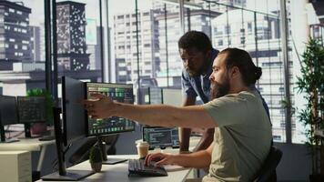 Manager correcting programmer mistakes while conducting code review to fix errors, identifying technical issues with company software. Team leader supervising IT staff member optimizing code, camera B video