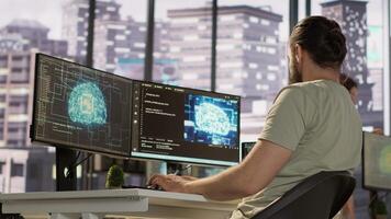 Employee utilizing AI resources and platforms to train and deploy machine learning models, handheld camera shot. Man monitoring and maintaining artificial intelligence company systems, camera A video