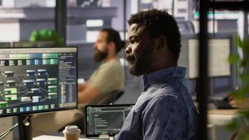 Programmer waiting for coworker to come help him fix applications issues, dealing with databases and server configuration. IT specialist optimizing company software, assisted by team leader video