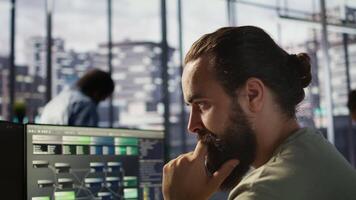 nachdenklich Mitarbeiter mit Computer zu analysieren Datensätze, konzentriert auf Vergleichen Datensätze und Überprüfung Buchhaltung Zahlen. schließen oben von Mann Konzentration auf lösen Aufgaben zum Mannschaft Projekt, Kamera b video