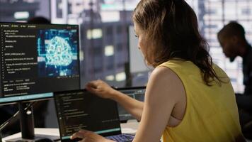 Woman in office using laptop to steal company secrets after being hired by competitor, hiding from manager. Sneaky employee closing notebook lid to hide while ilegally downloading data, camera A video