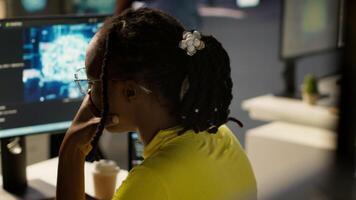 Staff member in office yawning during shift, feeling tired while looking at artificial intelligence software on PC. Exhausted african american AI company employee being sleepy in workspace, camera A video