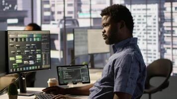 Developer working together with helpful colleague on artificial intelligence machine learning tech, improving company systems. IT specialist assisted by coworker to compare data video