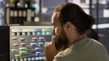 System administrator working with machine learning artificial intelligence critical to autonomous systems. Close up of man transforming data into predictive models, camera A video