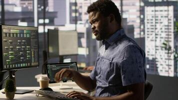 System administrator in pain, suffering muscle sprain while developing machine learning APIs. Man feeling backache from sitting at desk all day while training predictive models video