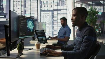 Admin creating AI machine learning models that can process and analyze data to improve decision making processes, looking at PC. Man programming in office using artificial intelligence tech, camera B video
