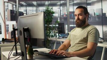 Meticulous staff member imputing data on computer in office. Adept worker at desk focused on typing company statistical numbers, working hard to finish job before deadline, camera B video