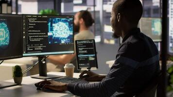 Admin creating AI machine learning models that can process and analyze data to improve decision making processes, looking at PC. Man programming in office using artificial intelligence tech, camera A video