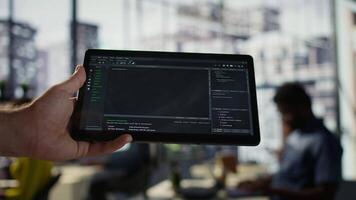 Software engineer using tablet to design algorithms that enable machines to learn from data. Close up of admin in office training and deploying large scale deep learning models with device, camera B video