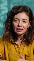 Vertical Smiling influencer doing story time type of for fans, filming in personal home studio. Jolly internet star telling subscribers about what happened to her, keeping audience engaged, camera A video
