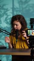 Vertical Content creator doing relaxing ASMR type of for fans, recording with professional camera. Online show host using advanced microphone and filming gear to create relaxing , camera A video