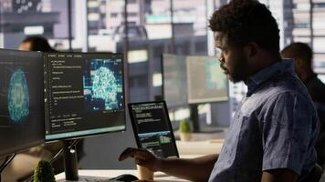 Manager coming to check on progress done by programmer creating AI machine learning models that can analyze data. Team leader supervising man doing artificial intelligence programming, camera A video