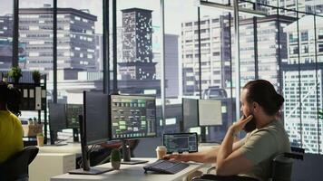 Person with impairment processing and analyzing data to automate decision making processes. IT specialist with disability programming in office, sitting in wheelchair, camera B video