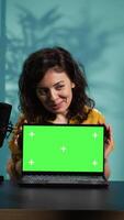 Vertical Online show host doing isolated screen laptop unboxing content, filming with professional camera. Tech expert doing chroma key notebook product placement, recording with advanced gear, camera B video