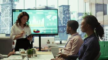 Diverse work team collaborating on project management tasks, utilizing smart technology and detailed analytics to optimize resource allocation and ensure enterprise objectives. Camera B. video